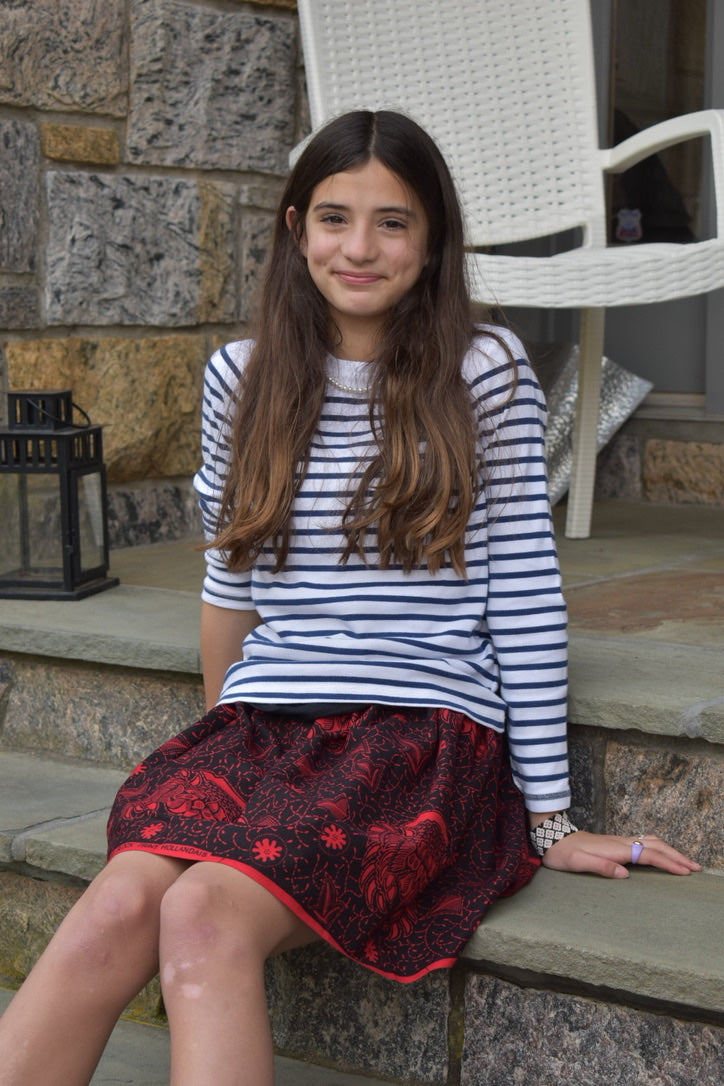 Black & red elastic mini skirt model sitting down