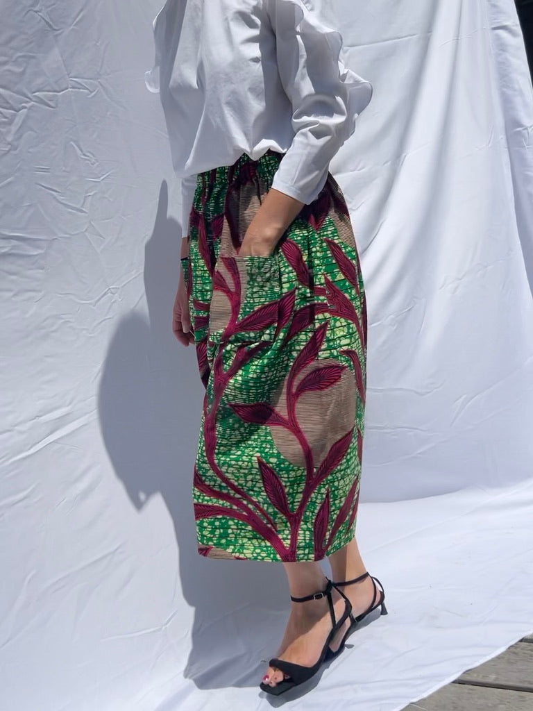 Green & Pink elastic waist mid skirt African print model is walking
