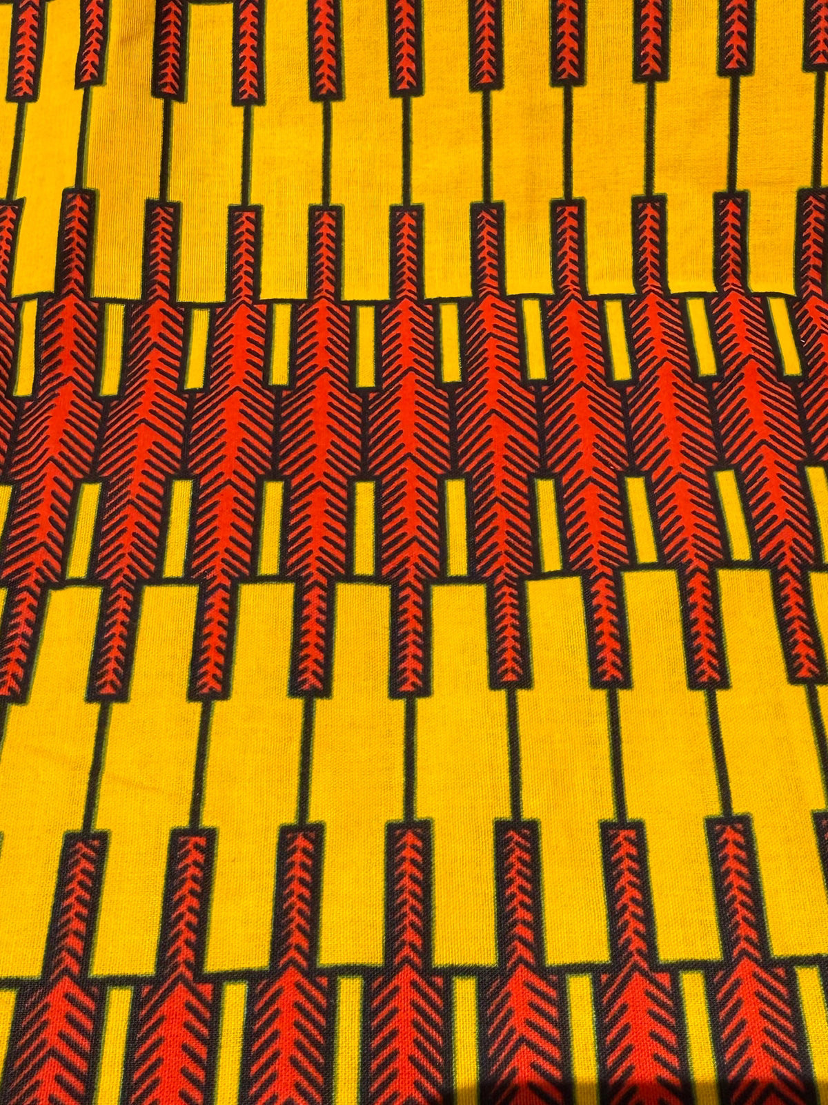 Patterned fabric with red and black design on a yellow background